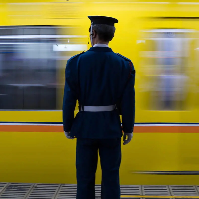 Station master standing before a yellow subway train
